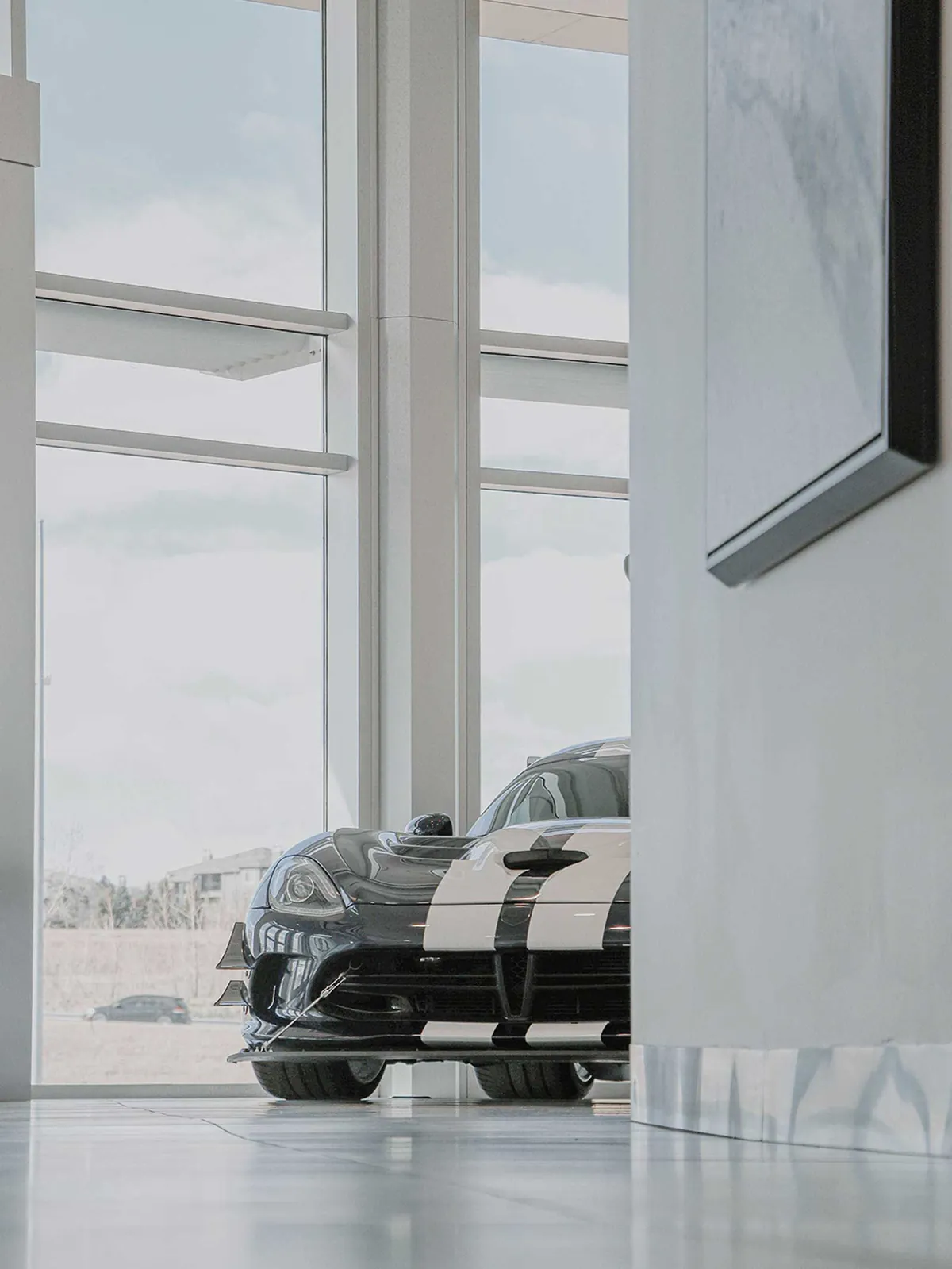 Sports car on display behind tall showroom windows