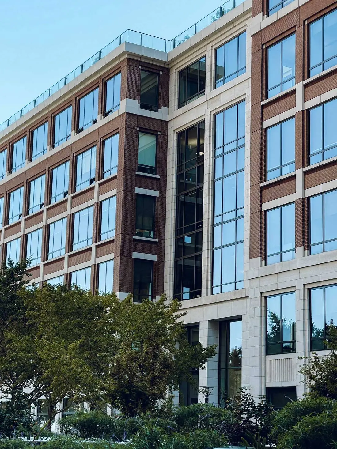 Multi-story brick and stone office building with rows of large windows