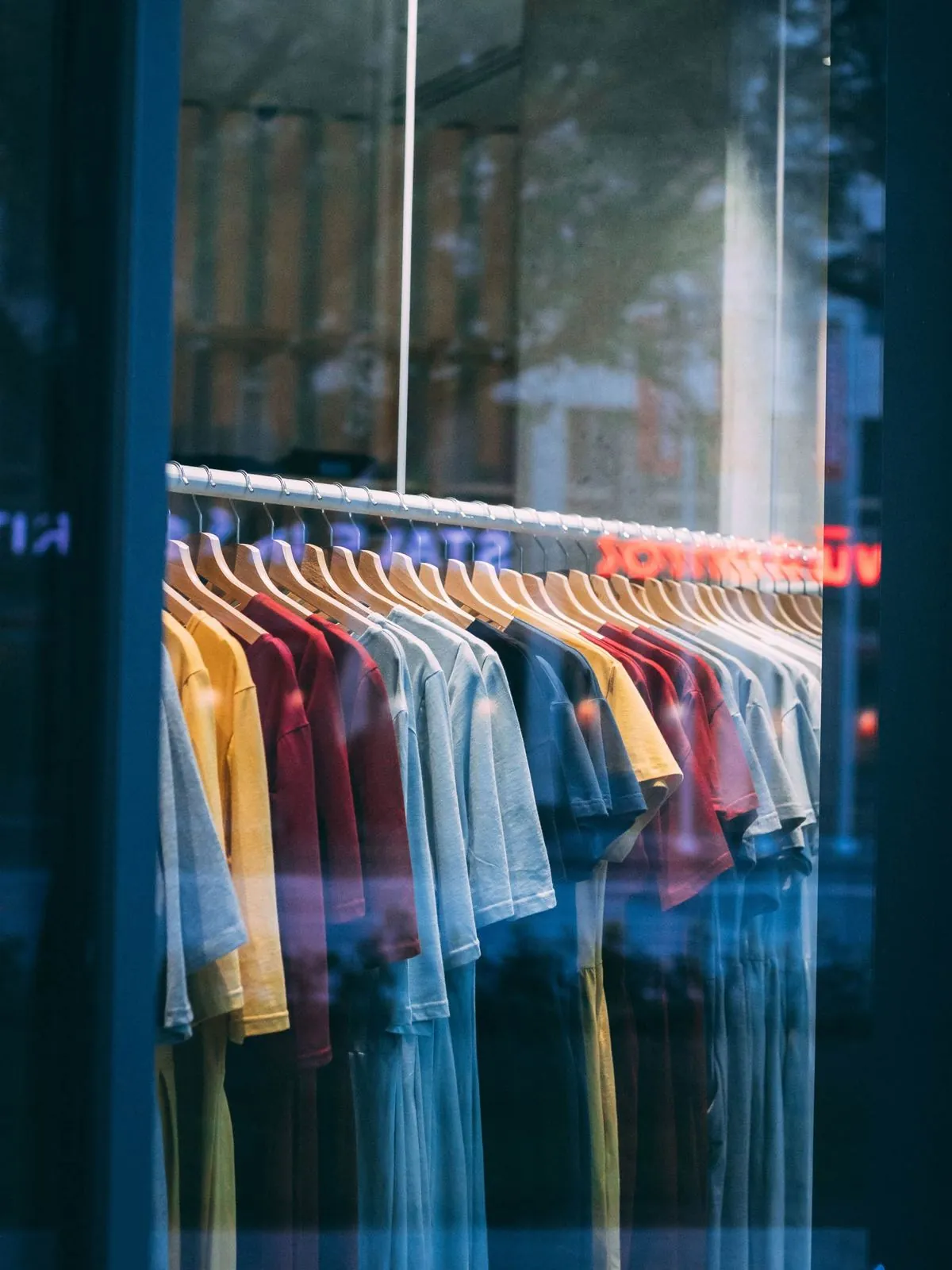 Clothing rack seen through a storefront display window